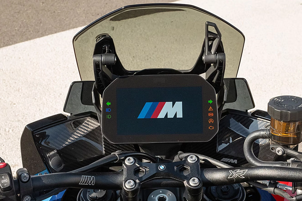 BMW Motorrad M 1000 XR vue de face avec phares allumés.