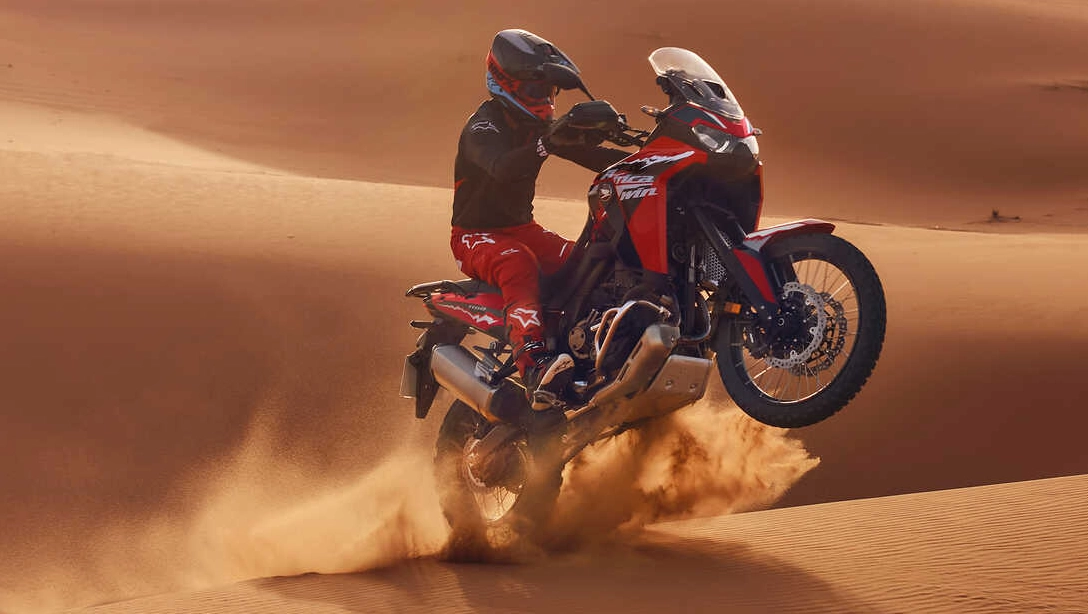 Vue latérale de la Honda Africa Twin sur route, fond sombre