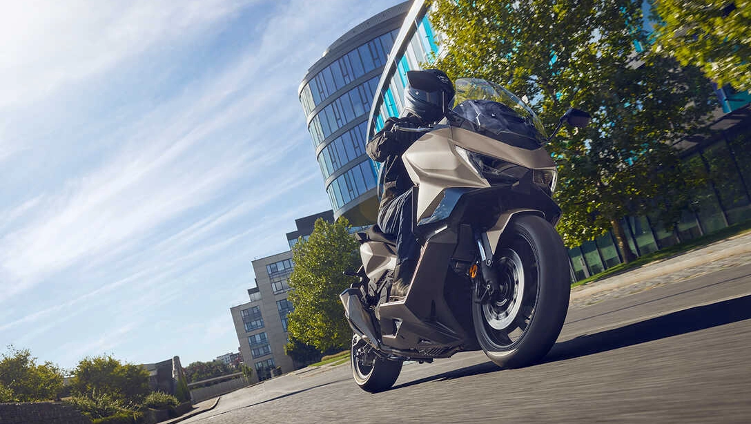 Vue latérale du Honda Forza 750 sur route de ville de nuit