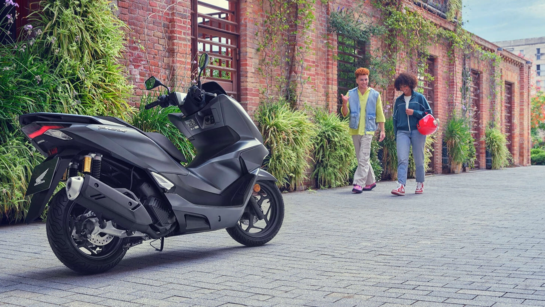 Honda PCX125 sur fond noir, vue latérale du scooter en ville