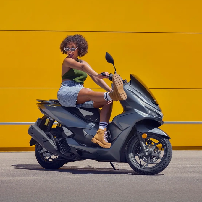 Honda PCX125 stationné devant un café moderne