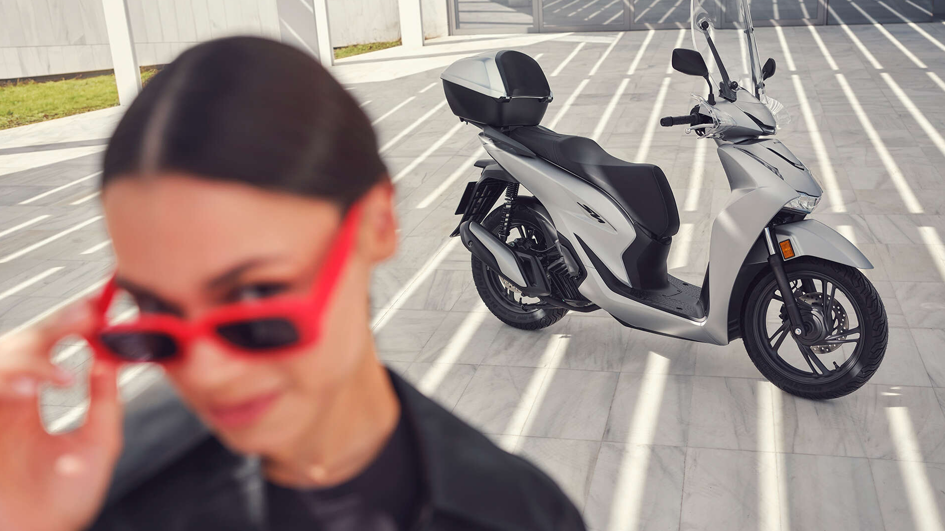 Honda SH125i en mouvement sur route urbaine