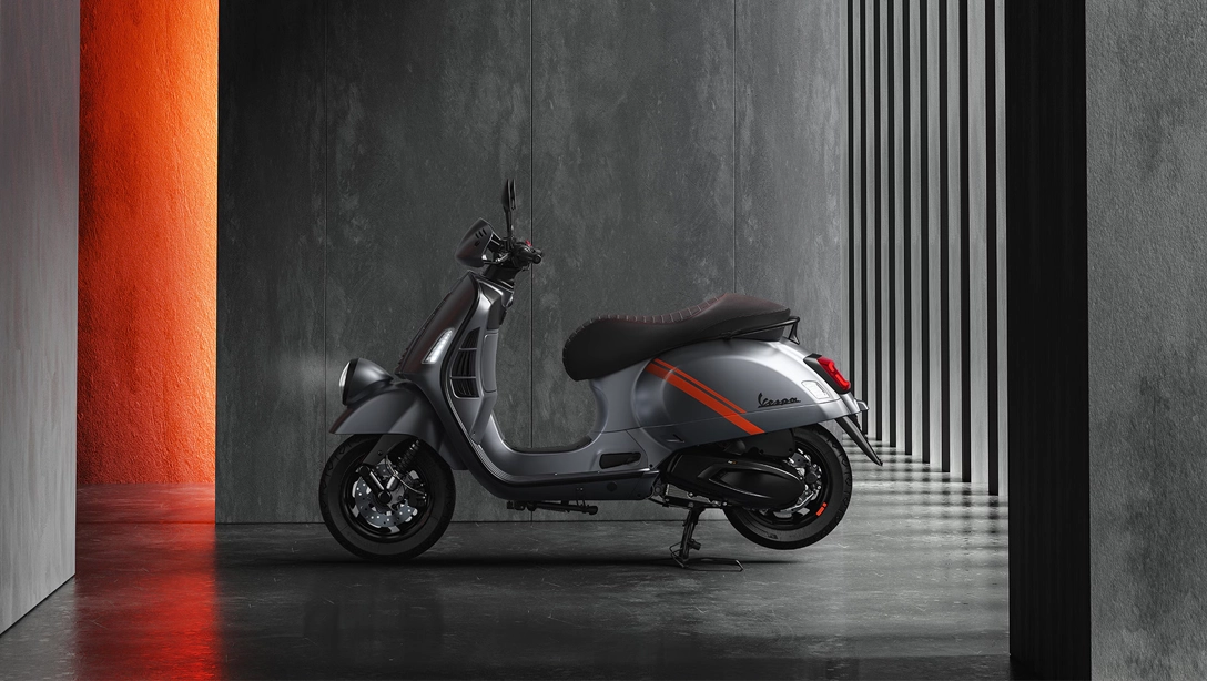 Vue latérale de la Vespa GTV sur fond sombre, mettant en avant son style rétro.