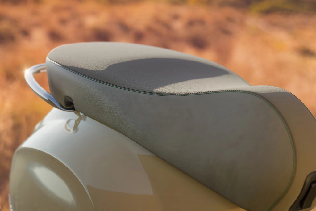 Vespa Primavera stationnée devant un café urbain, illustrant son usage citadin.